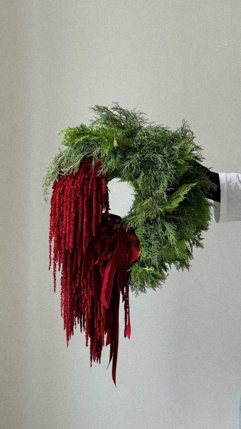 A fresh Christmas wreath of conifer with trailing red amaranthus and velvet ribbon, by Maison Bloom, Bali